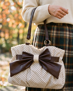 Hand holding the Colette Bow Bag in Cream Dot